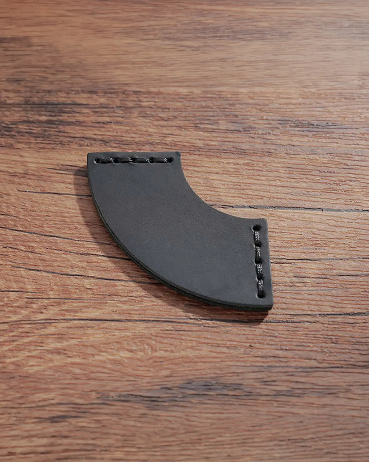 Black leather corner bookmark with curved fan shape and matching stitched ends