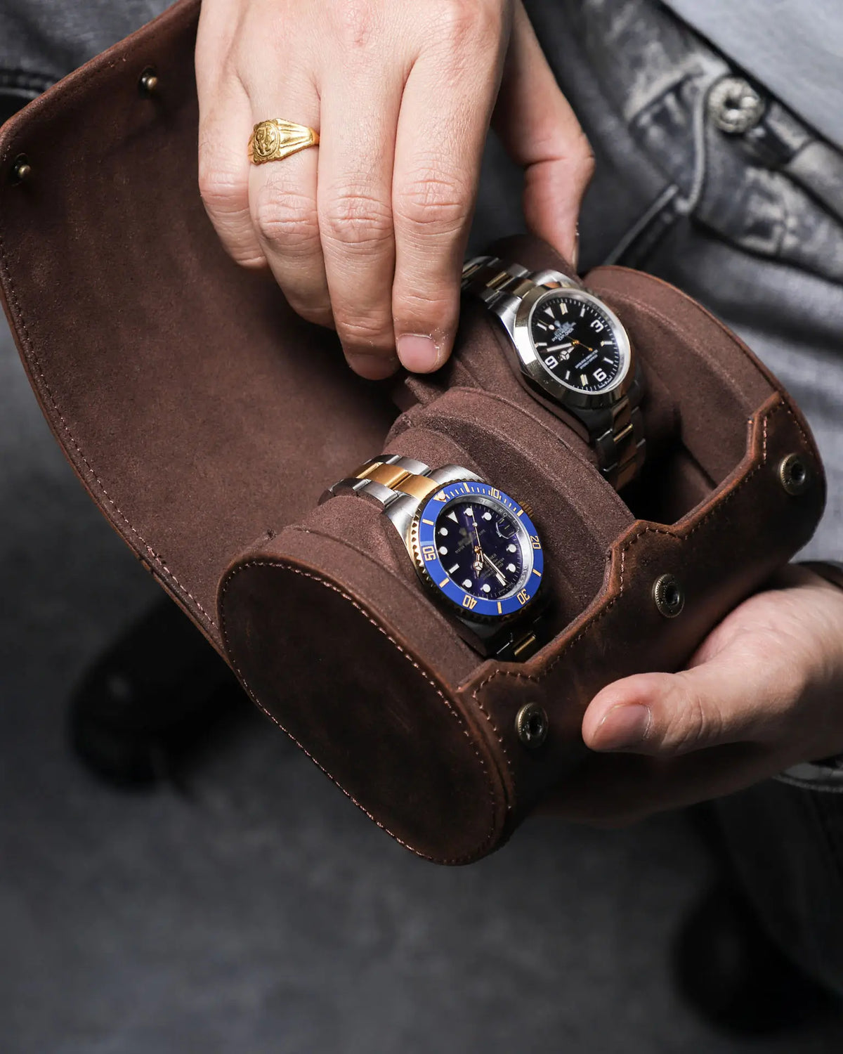 Hands placing a metal-bracelet watch into an open double-watch roll
