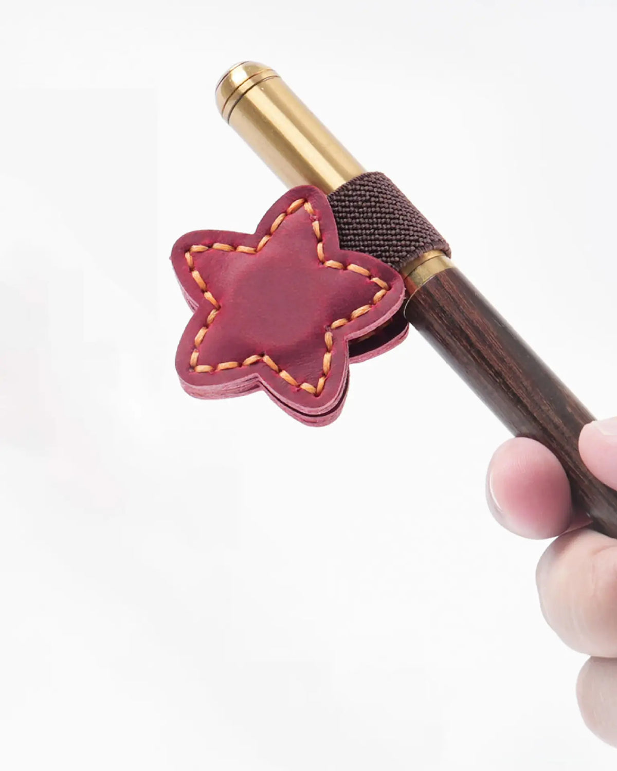 Crimson star leather magnetic bookmark holding a fountain pen in its elastic pen loop