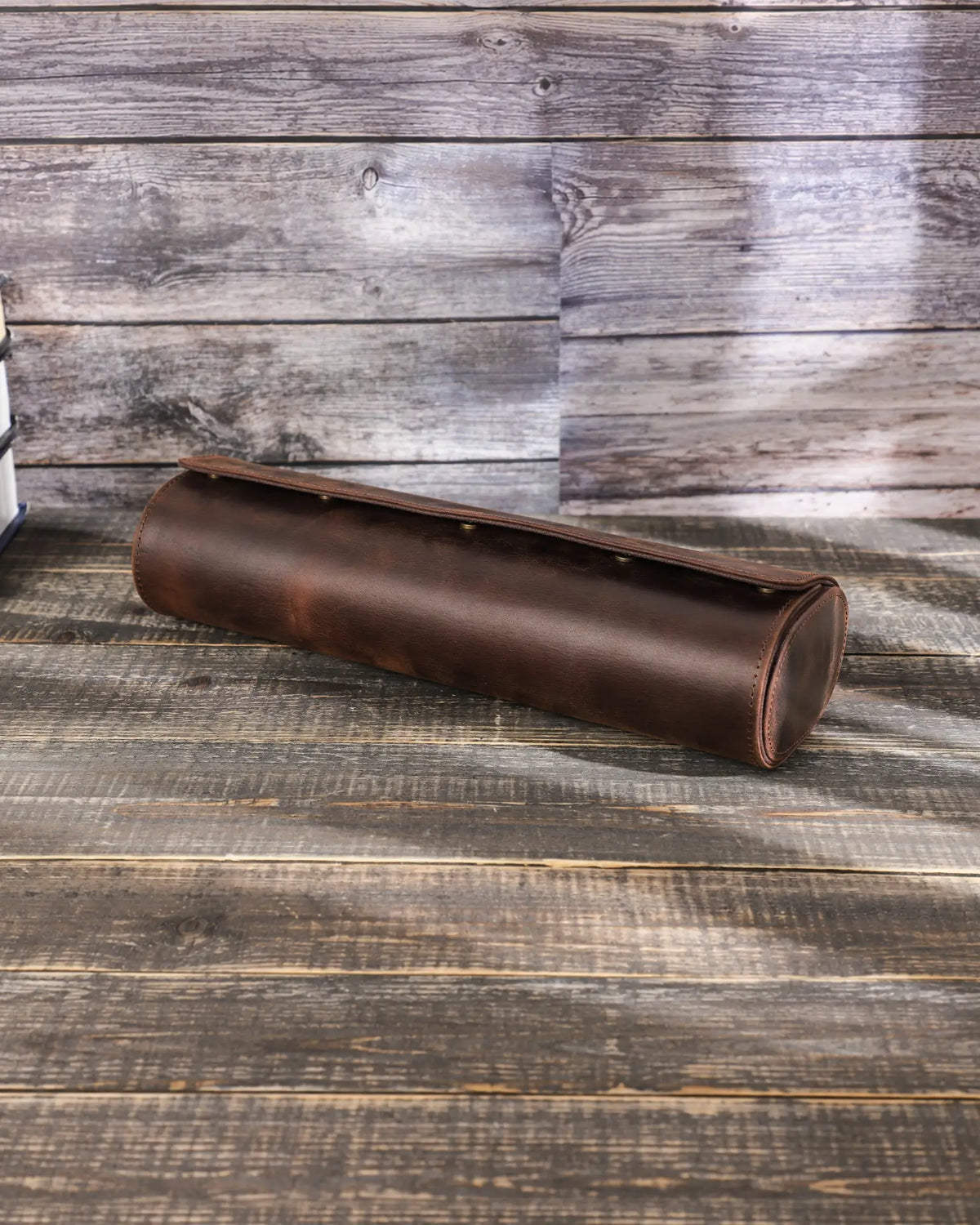 Closed Espresso four-watch roll at an angle, showing its curved leather body and flap.