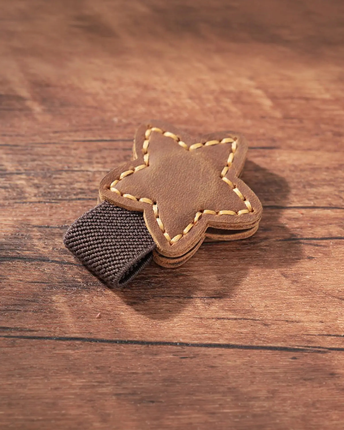 Cognac leather star magnetic bookmark with contrast stitching and brown elastic pen loop