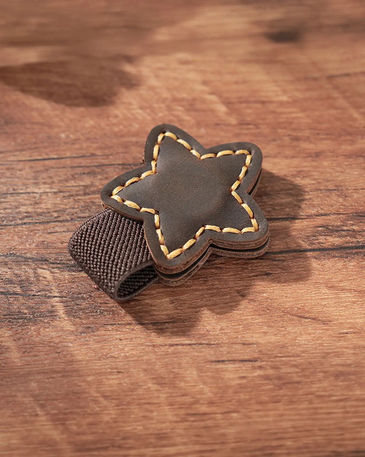 Espresso leather star magnetic bookmark with tan stitching and brown elastic pen loop