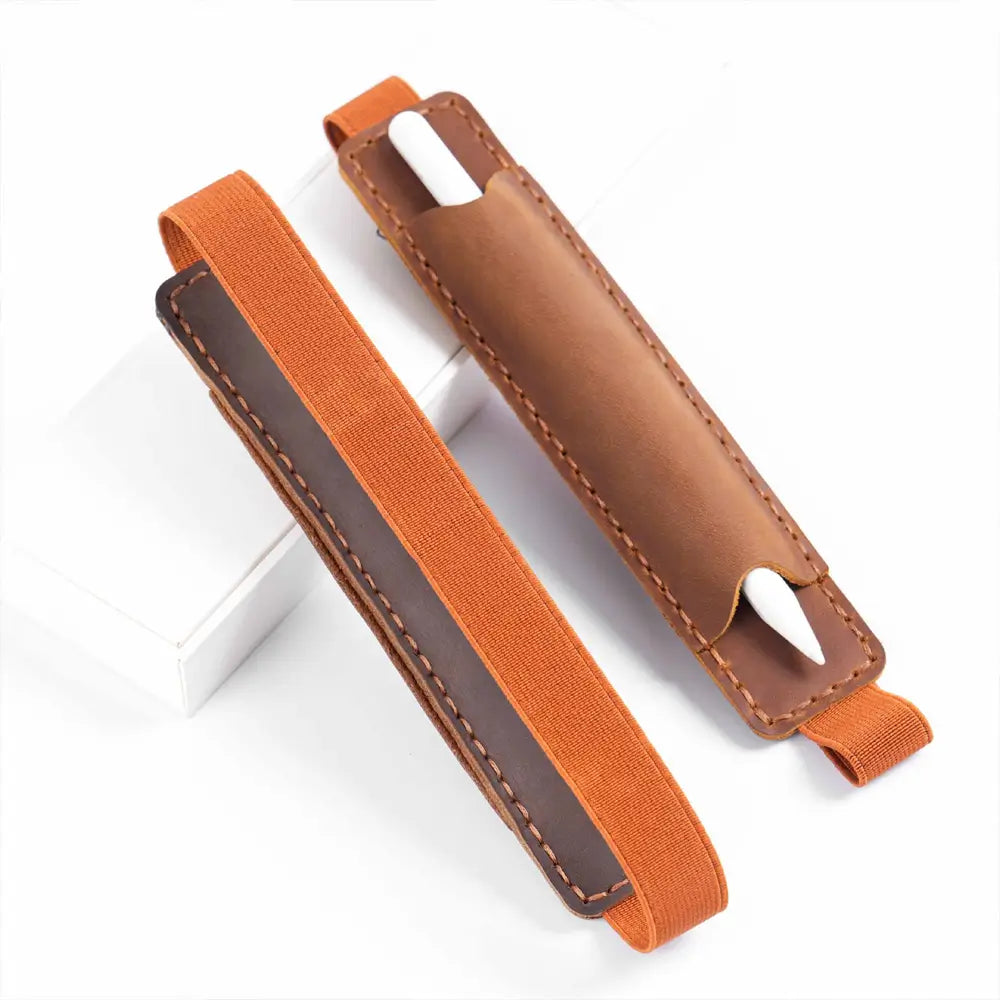 Pen inserted in leather holder on journal cover