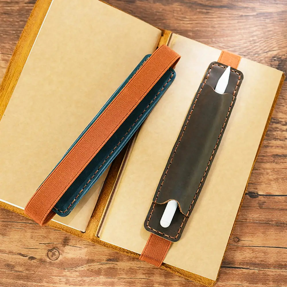 Pen inserted in leather holder on journal cover