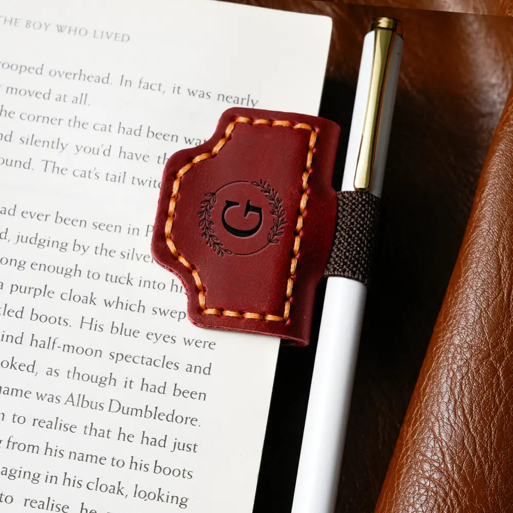 The red square bookmark is sandwiched with a white pen on the book.