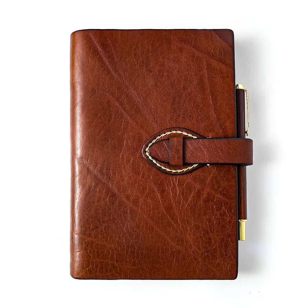 Brown refillable leather journal with strap closure front view