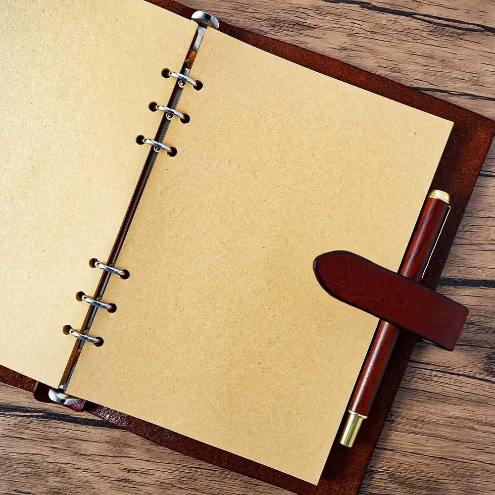 Refillable leather journal open showing 6-ring binder and kraft pages