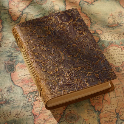 The carved leather diary is on an old map.