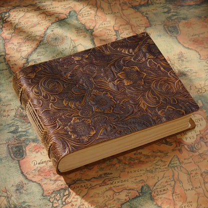 The carved leather diary is on an old map.