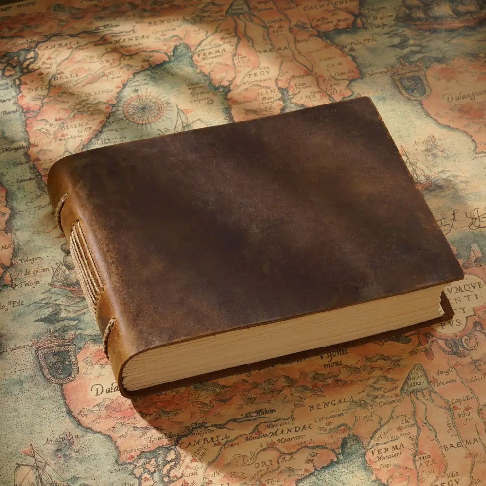The brown vintage leather diary is on an old map.