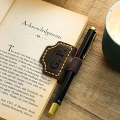 Pen inserted in leather bookmark pen holder