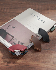 Colorful leather corner bookmarks marking pages in a book
