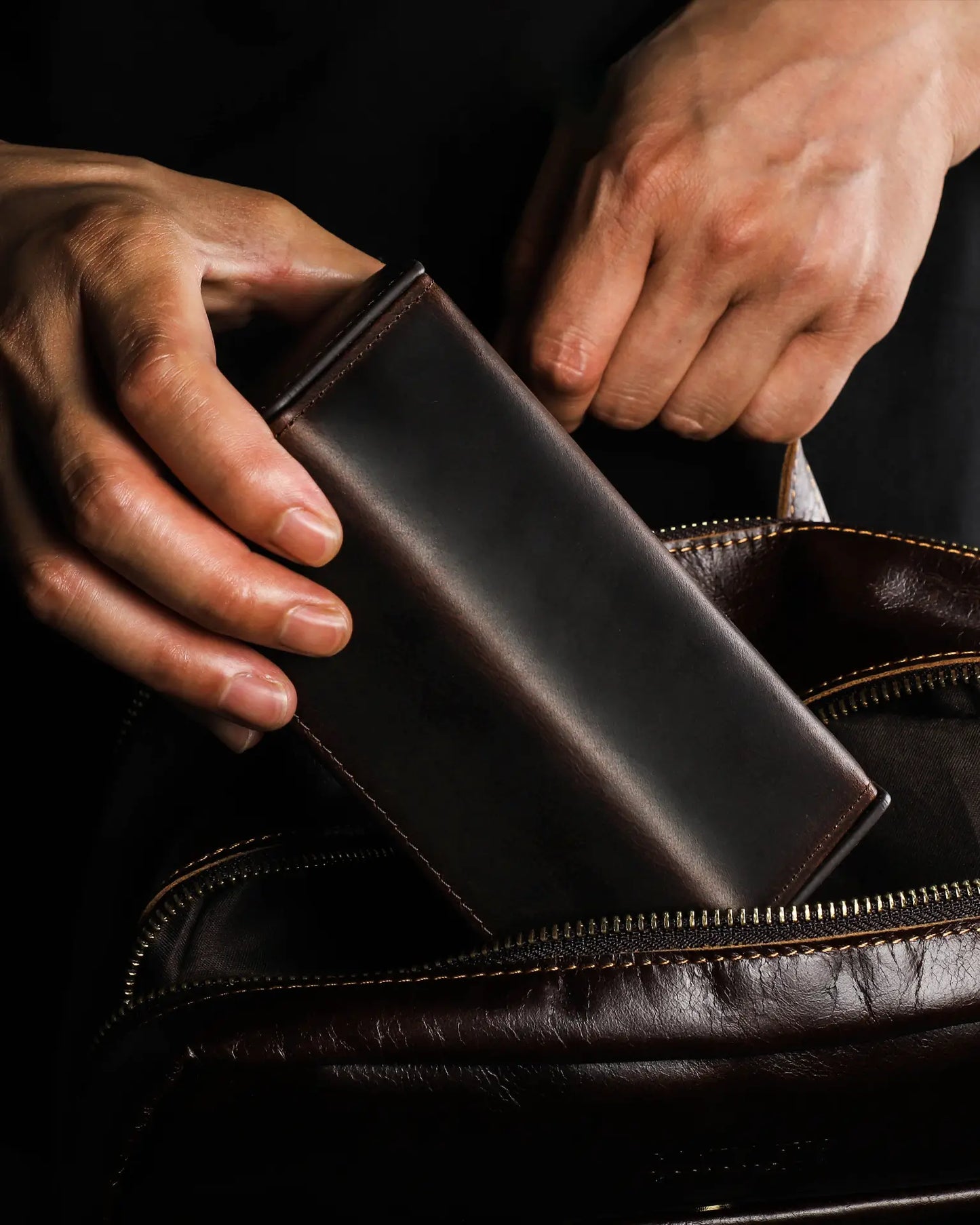 Man placing Legacy Hex leather watch box into travel bag showing compact size