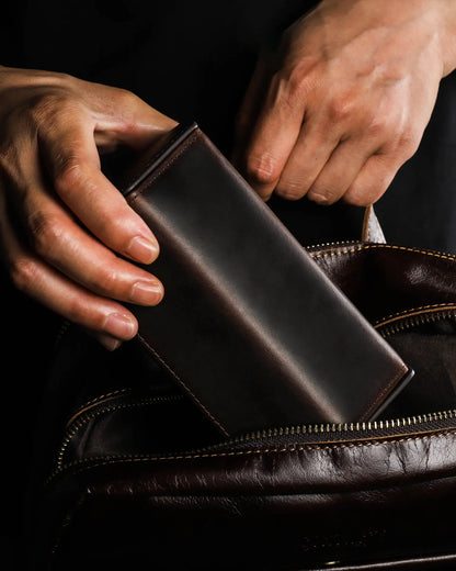 Man placing Legacy Hex leather watch box into travel bag showing compact size