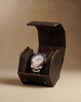 Open dark brown hex watch box holding one watch