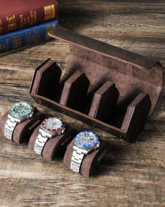 Open empty hex watch box beside three watches on pillows