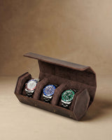 Open dark brown hex watch box holding three watches