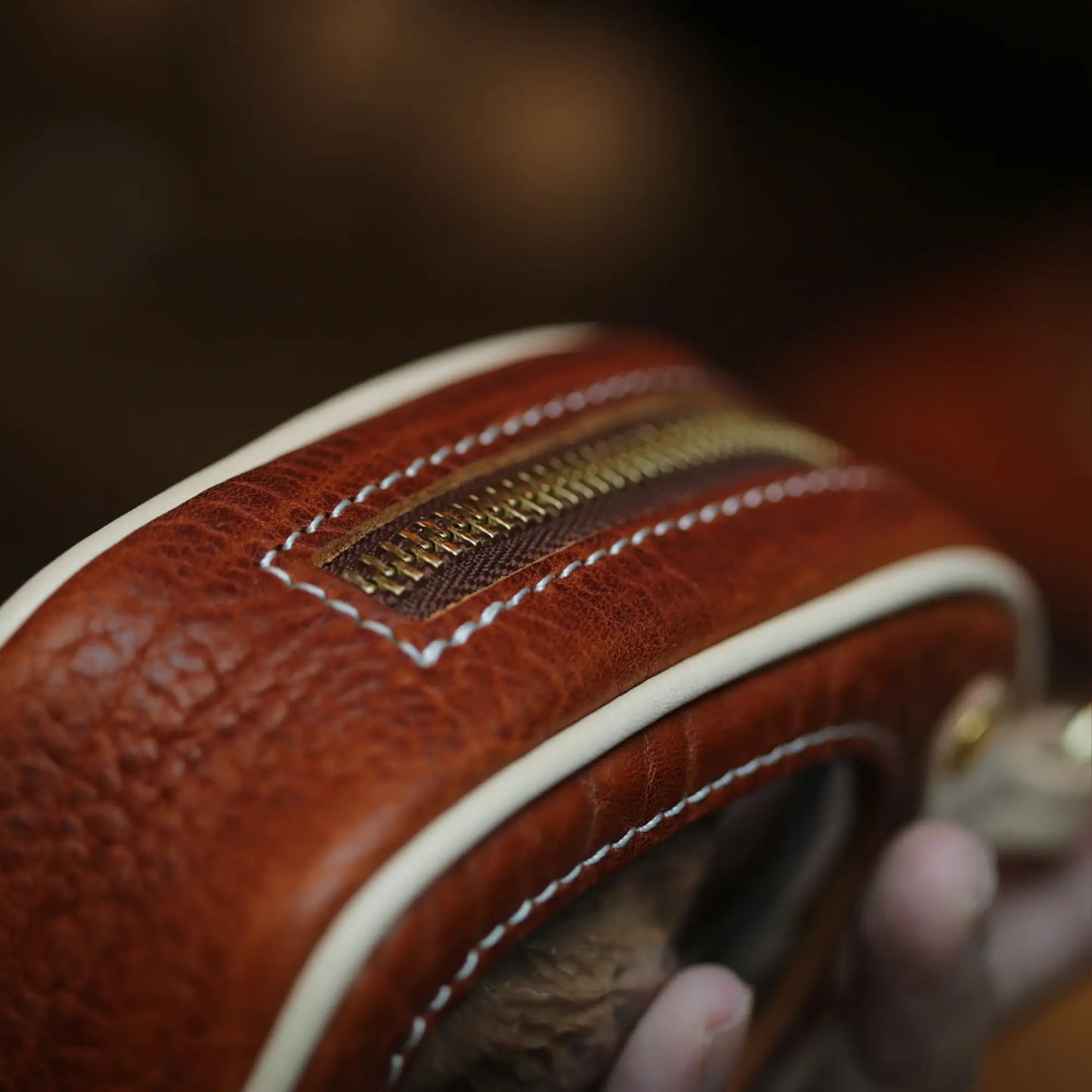 Close-up of YKK antique brass zipper on handmade full grain leather pouch