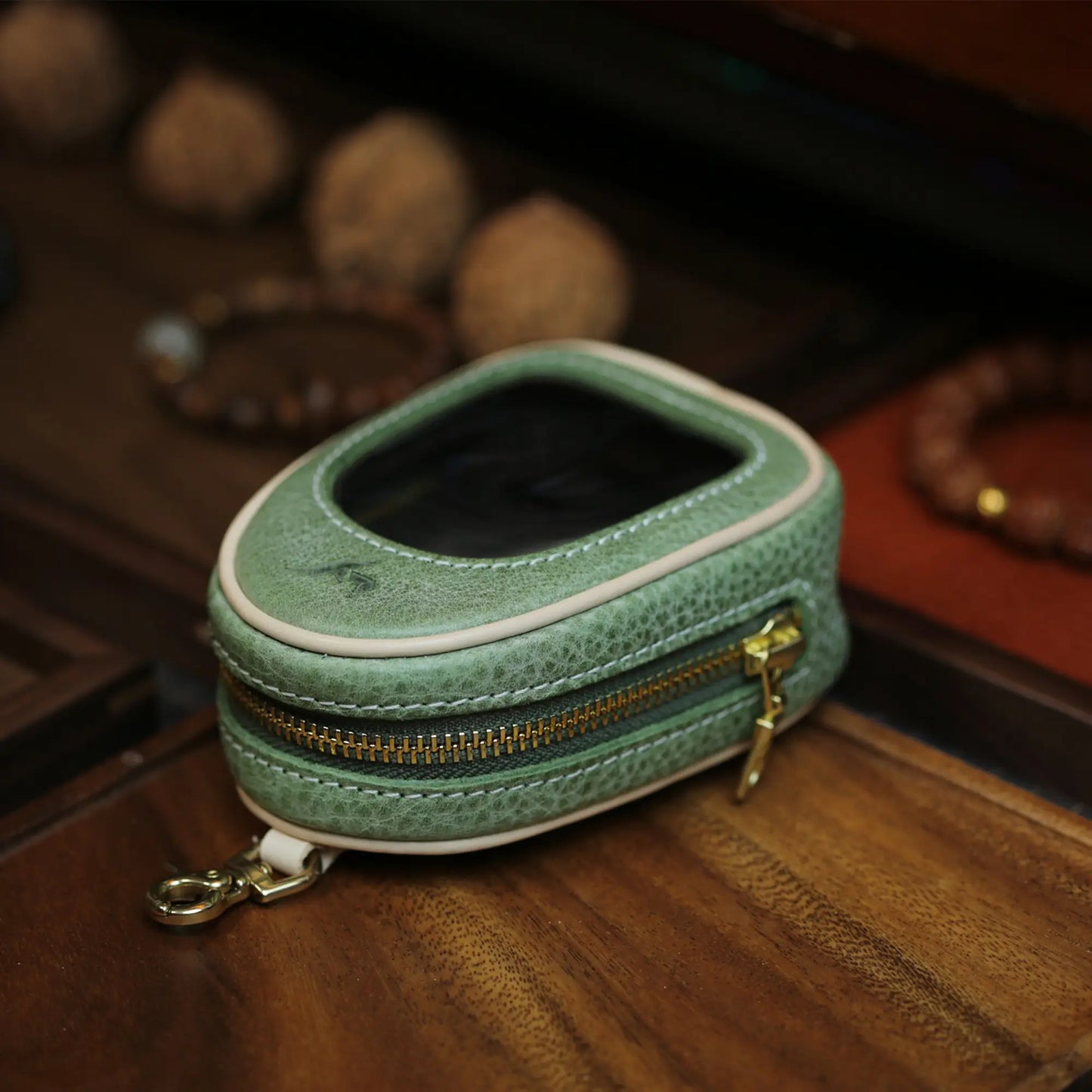 Sage green leather window pouch with brass hardware and soft clear top panel