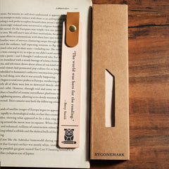 Bookmark with a quote on an open book on a wooden surface