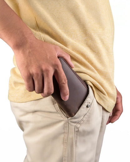 Man putting leather watch pouch into pants pocket showing compact travel size