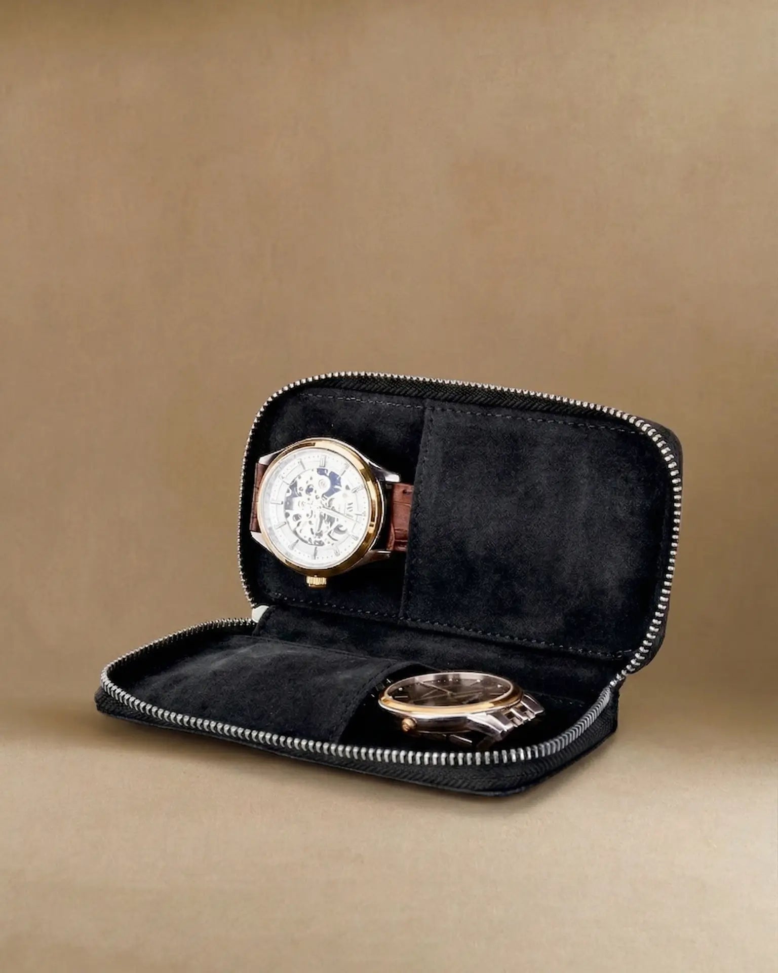 Black leather watch case open with two luxury watches in soft suede slots