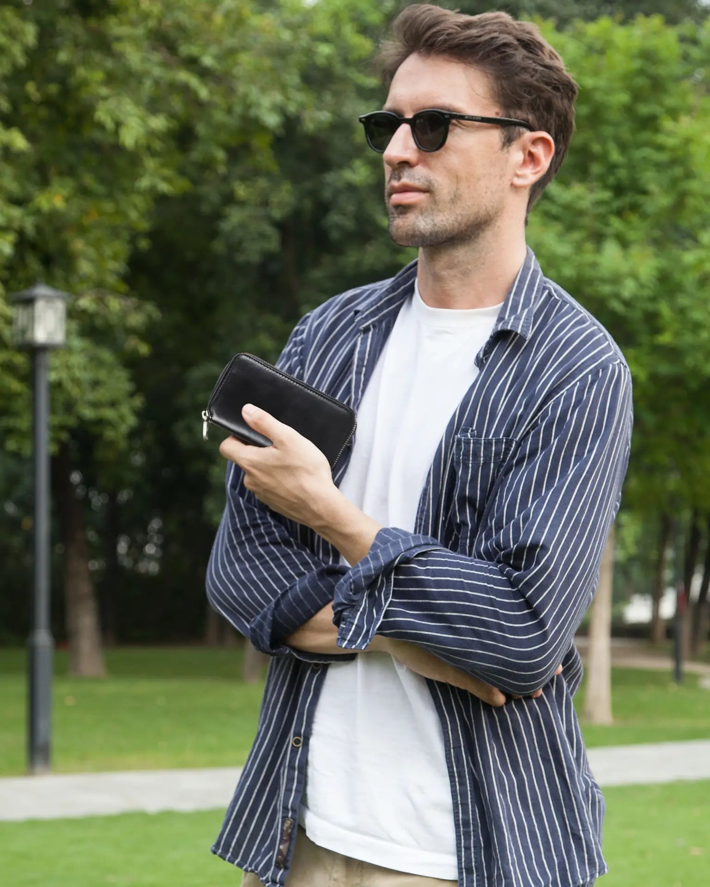 Man holding black leather watch pouch outdoors lifestyle photography