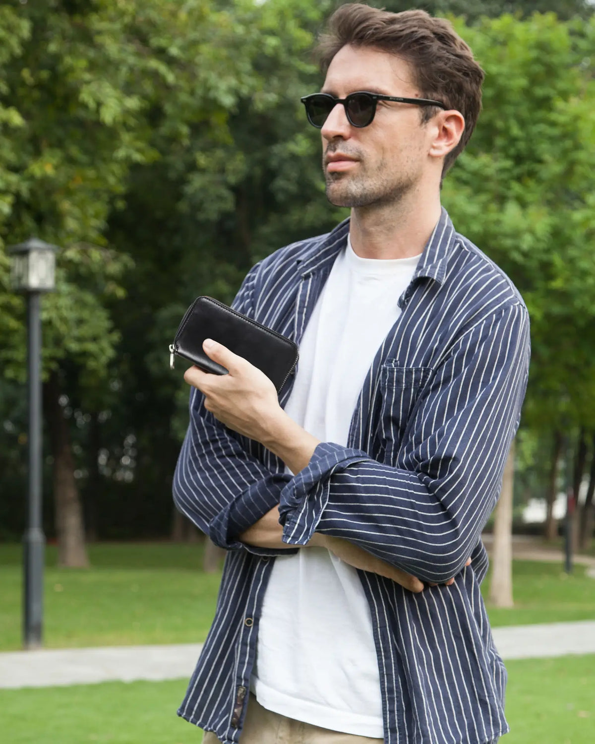 Man holding black leather watch pouch outdoors lifestyle photography