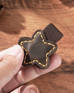 Close-up of an Espresso star leather magnetic bookmark with contrast stitching and elastic pen holder