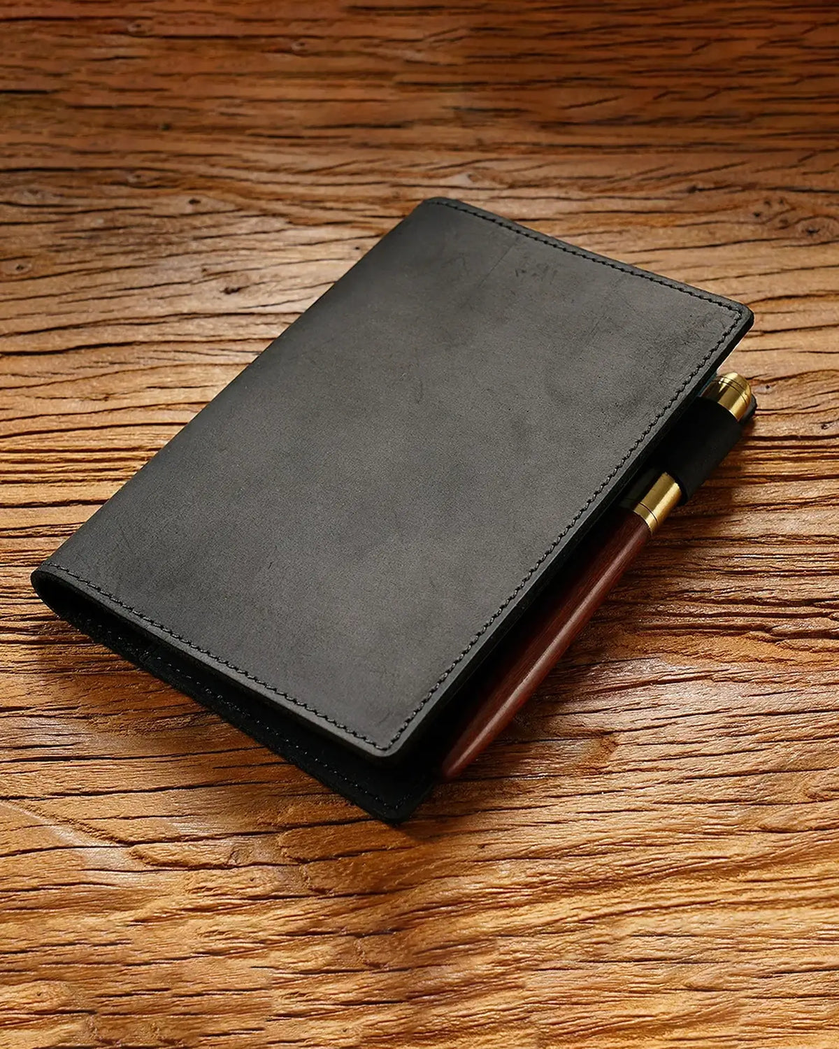 Black A6 leather writing folio with a pen beside the cover