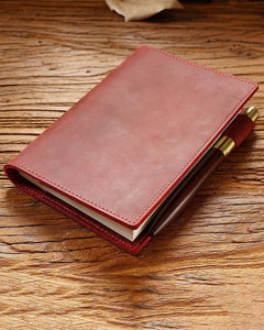 Crimson A6 leather writing folio holding a bound notebook beside the pen loop