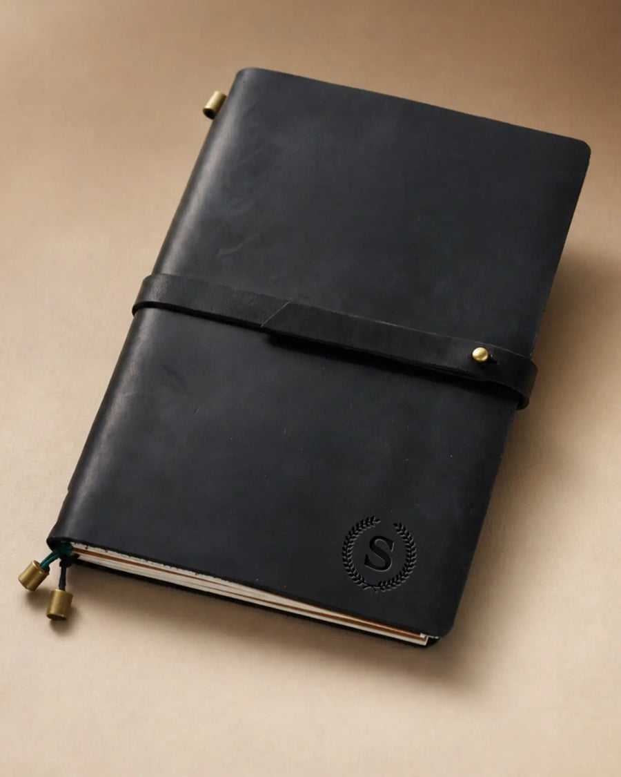 Black A5 leather traveler’s notebook with wrap strap and monogram example