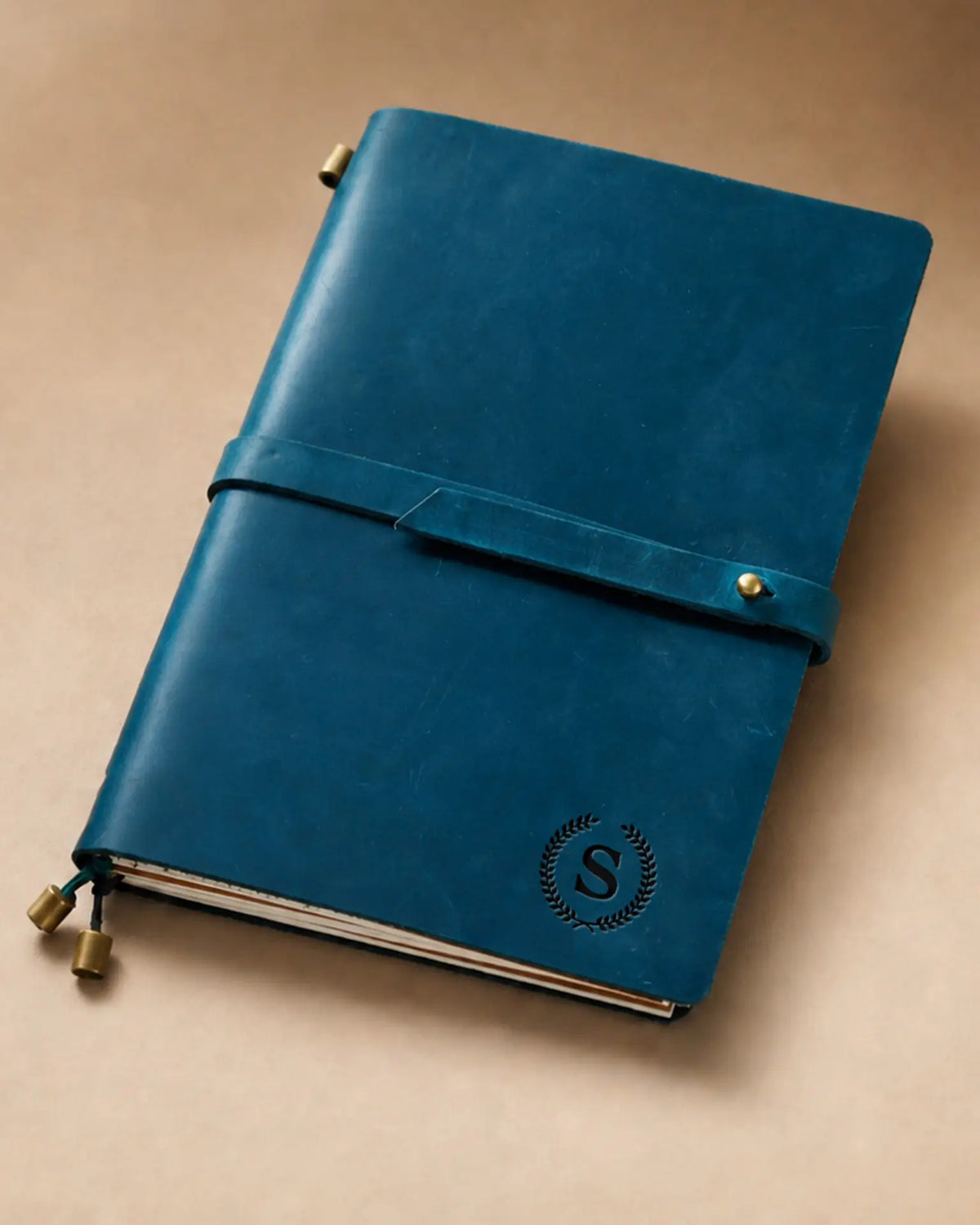 Teal Blue A5 leather traveler’s notebook with wrap strap and monogram example
