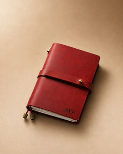 Crimson Passport-Size leather traveler’s notebook with wrap strap and monogram example