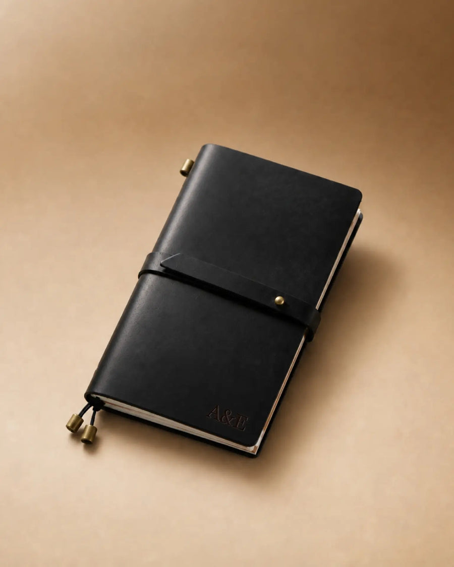 Black Personal-Size leather traveler’s notebook with wrap strap and monogram example