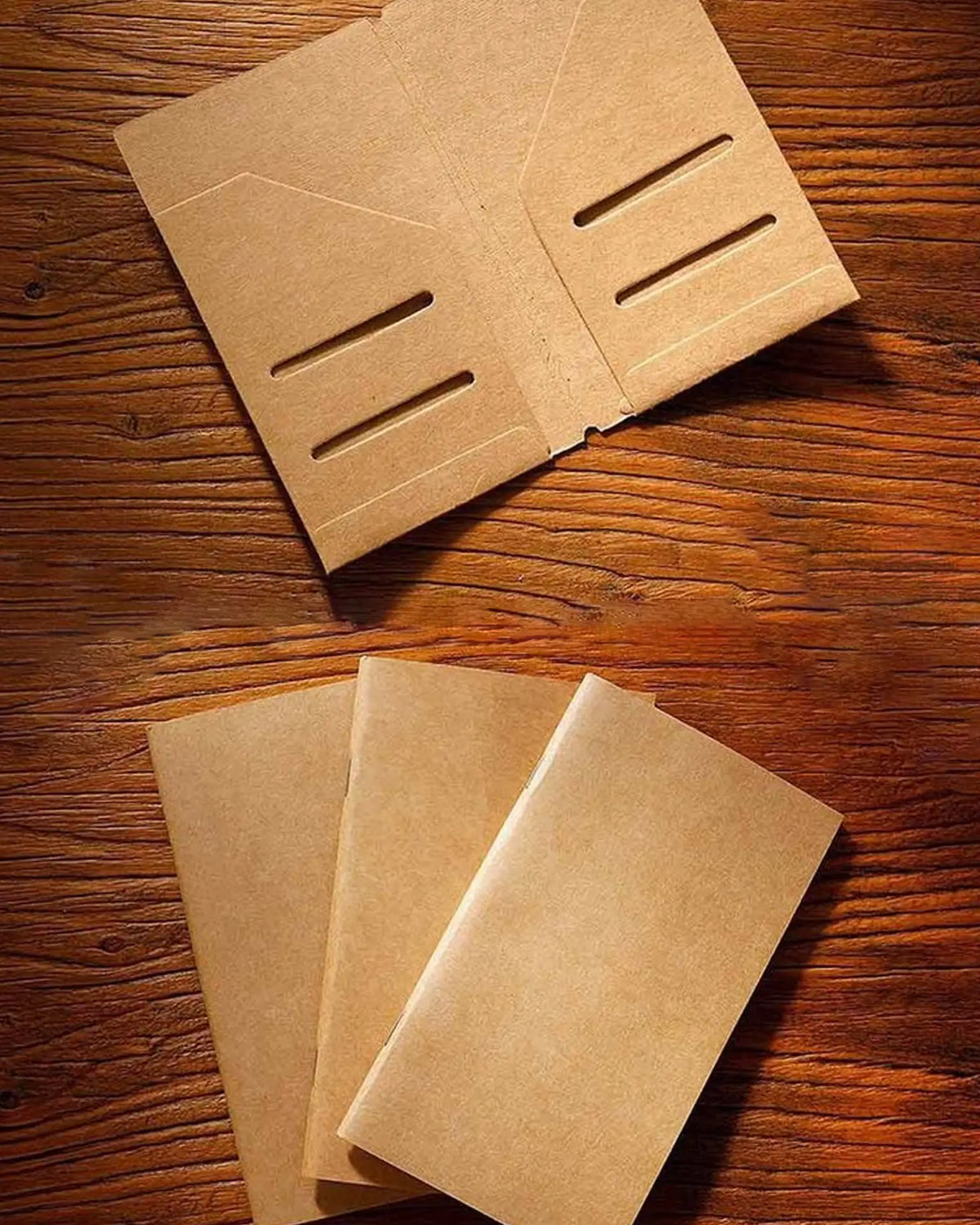 Three notebook inserts beside an open kraft card holder with slots