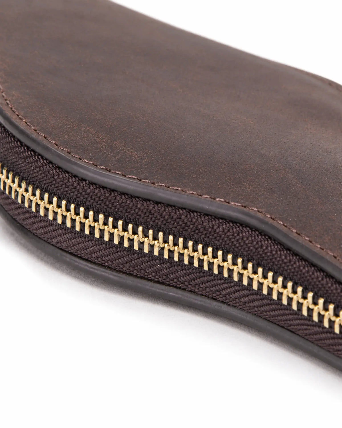 Detail of the gold-tone zipper teeth and stitched edge on the Espresso watch case.