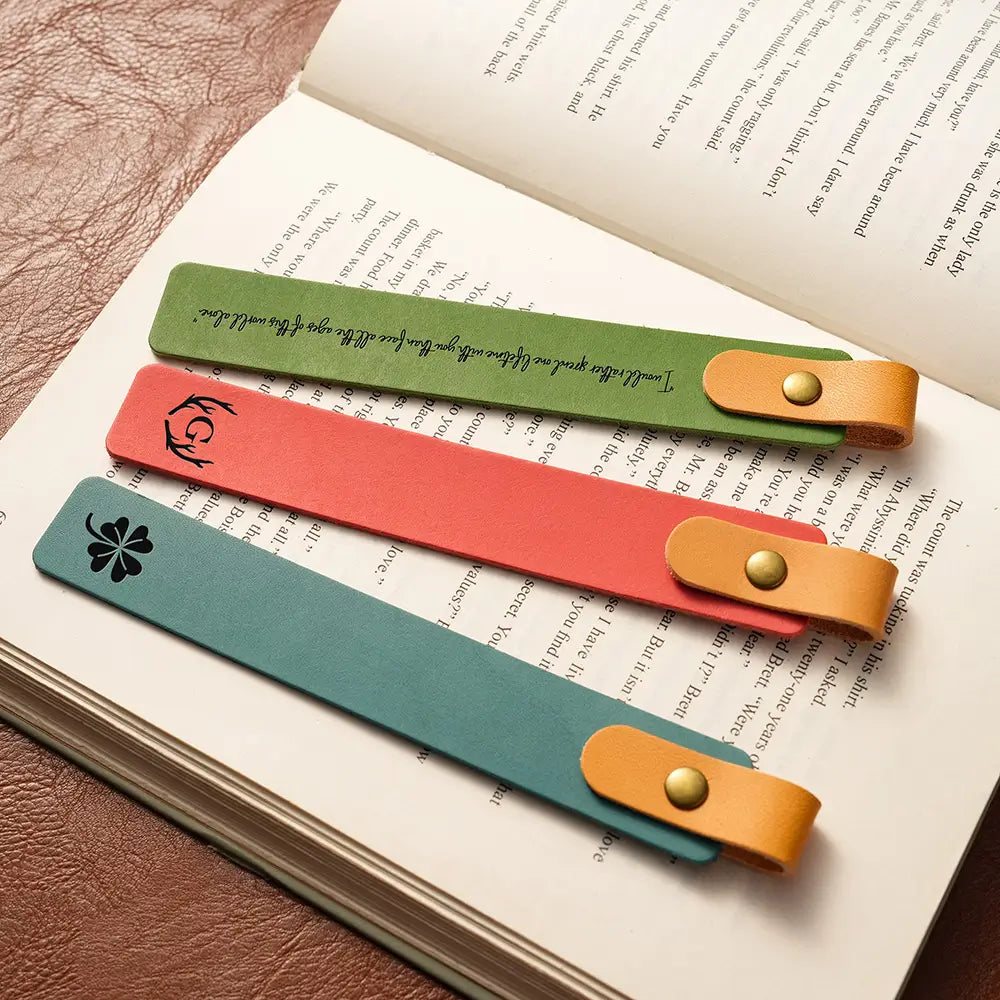 Three colorful leather bookmarks on an open book
