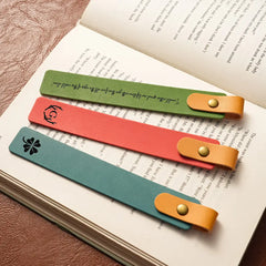 Three colorful leather bookmarks on an open book
