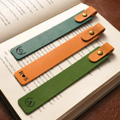 Three leather bookmarks with monograms on an open book