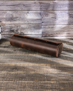 Closed Espresso four-watch roll at an angle, showing its curved leather body and flap.