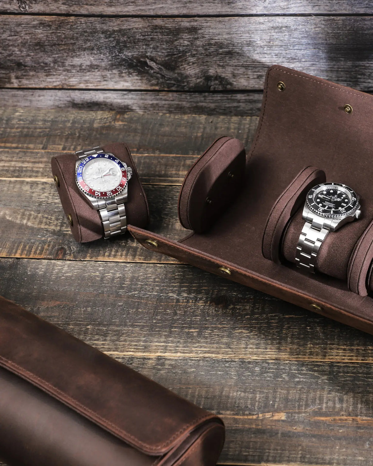 Detail of a removable watch cushion beside the open roll, showing the side snap fasteners.