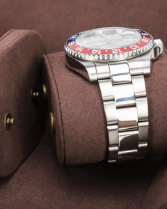 Close-up of a watch on its brown cushion between the interior dividers of the watch roll.