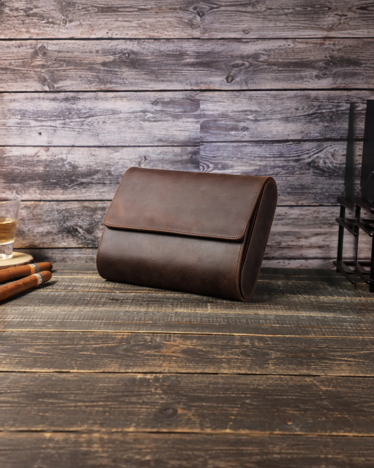 Closed Espresso six-watch case on a wooden table, showing the curved leather body and front flap.