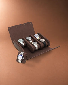 Open six-watch case with five watches inside and one watch on a removable cushion beside it.
