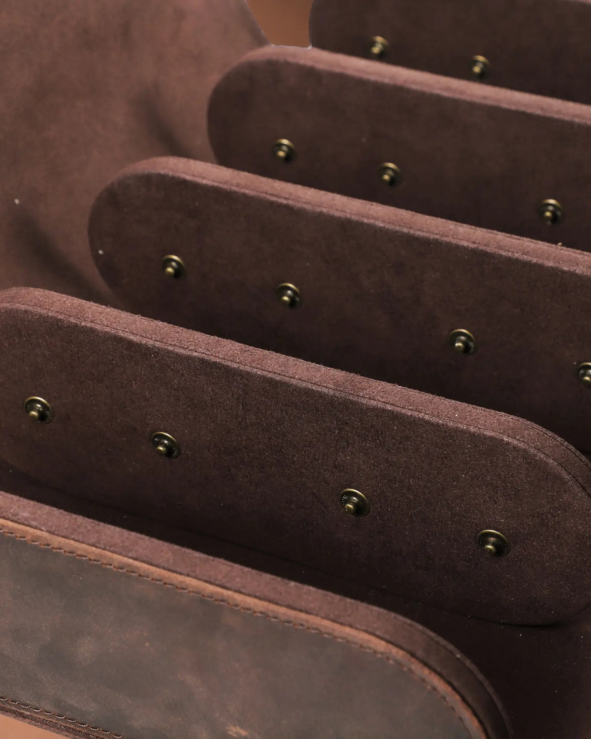 Detail of three brown interior dividers and the cushion snap fittings inside the empty eight-watch case.