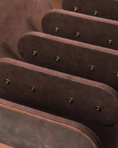 Detail of three brown interior dividers and the cushion snap fittings inside the empty eight-watch case.