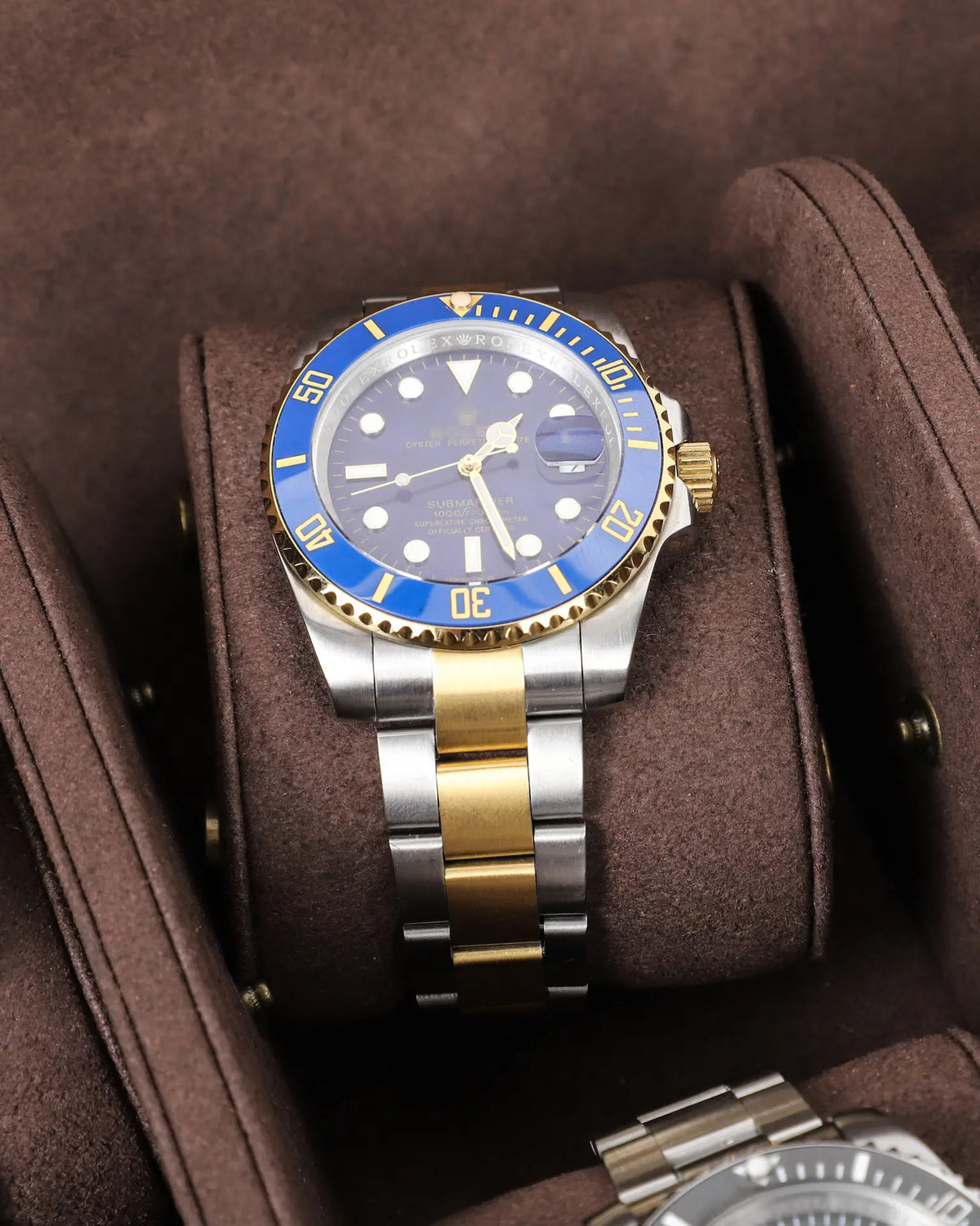 Close-up of a watch on a removable brown cushion between the interior dividers of the eight-watch case.