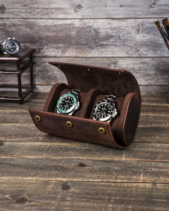 Brown double watch roll open on a wooden table, showing two watch cushions and the central divider.