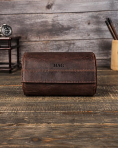 Front view of a brown double watch roll with an HAG monogram centered on the flap. Personalization example.